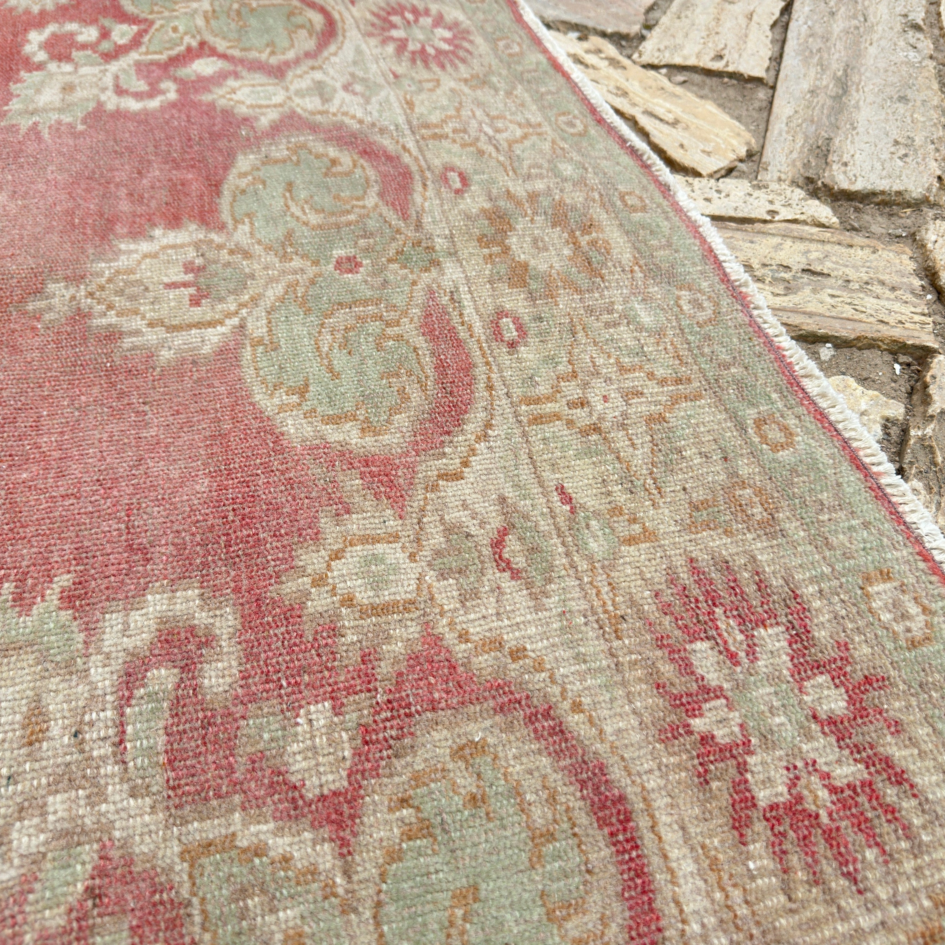 Close-up of the red vintage turkish rug showing traditional details, hand-knotted weave, wool and cotton and low pile.