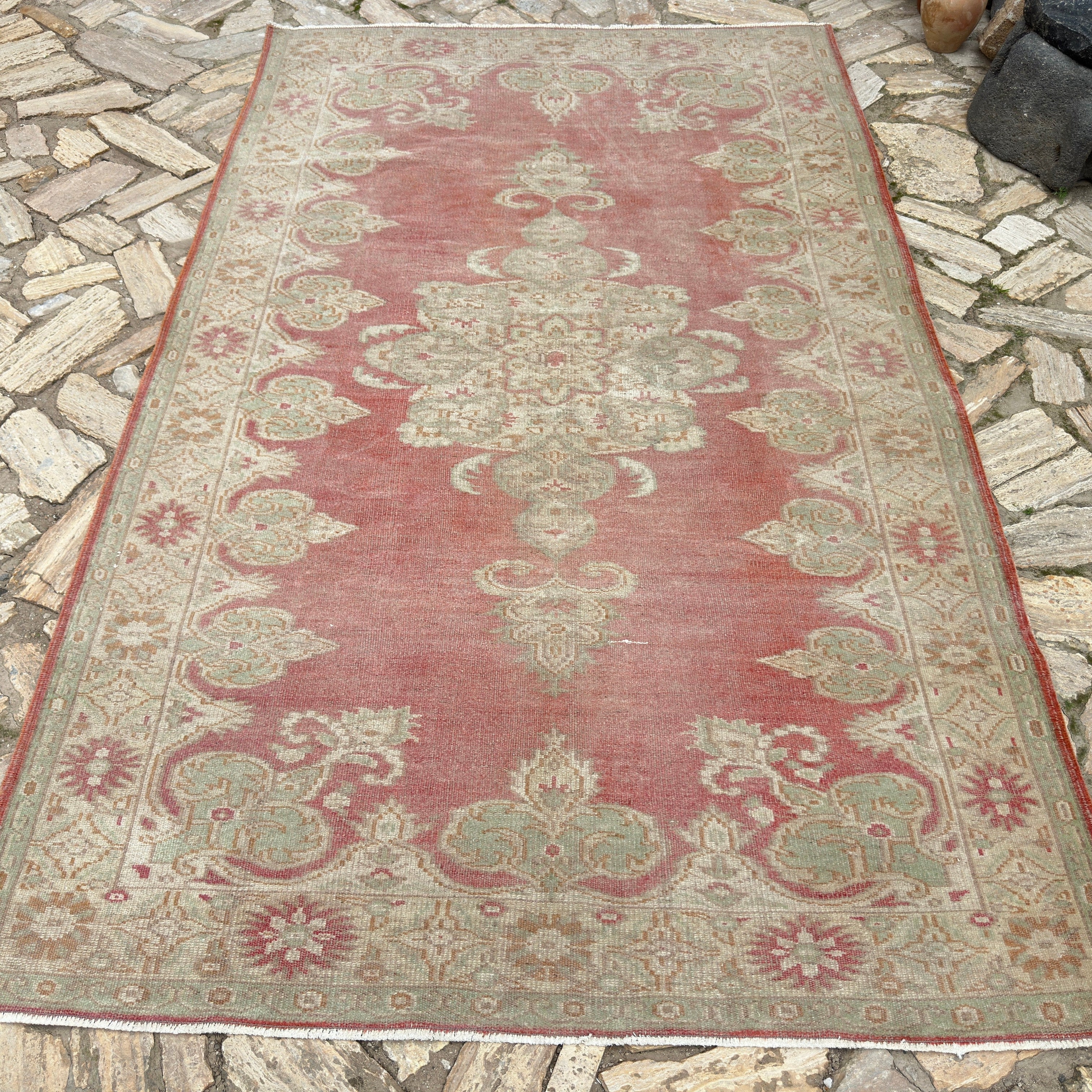Red 5' x 10' vintage turkish rug in wool and cotton, shown on the floor.