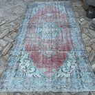 Red 5' x 10' vintage turkish rug in wool and cotton, shown on the floor.