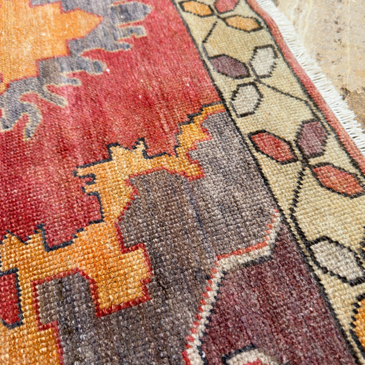 Close-up of the red vintage turkish rug showing traditional details, hand-knotted weave, wool and cotton and low pile.
