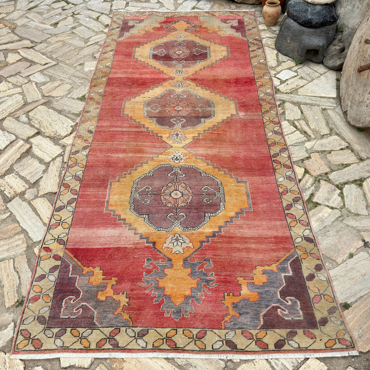 Red 5' x 11' vintage turkish rug in wool and cotton, shown on the floor.