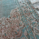 Close-up of the blue vintage turkish rug showing medallion details, hand-knotted weave, wool and cotton and low pile.