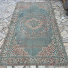 Blue 5' x 8' vintage turkish rug in wool and cotton, shown on the floor.