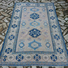 Blue 5' x 8' vintage turkish rug in wool and cotton, shown on the floor.