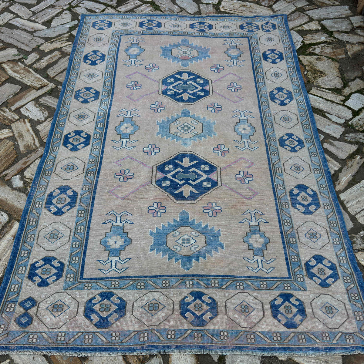 Blue 5' x 8' vintage turkish rug in wool and cotton, shown on the floor.