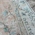 Close-up of the orange vintage turkish rug showing medallion details, hand-knotted weave, wool and cotton and low pile.