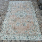 Orange 5' x 8' vintage turkish rug in wool and cotton, shown on the floor.