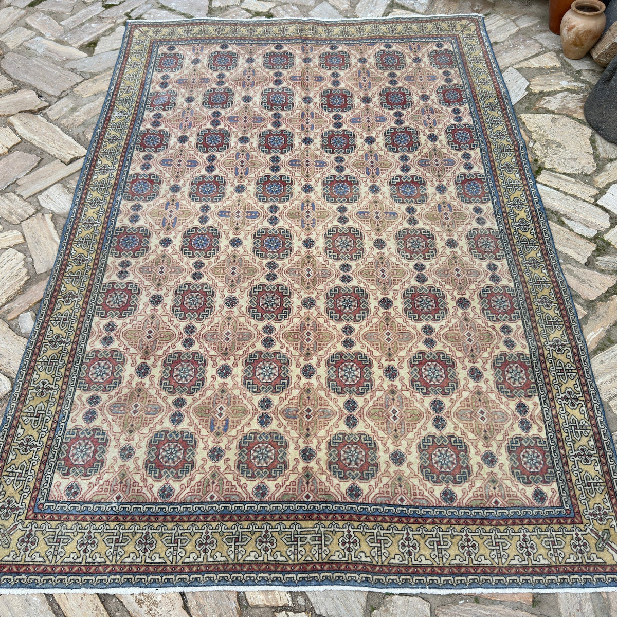 Pale Red 5' x 8' vintage turkish rug in wool and cotton, shown on the floor.
