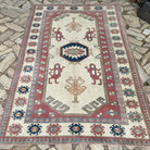 Pink 5' x 8' vintage turkish rug in wool and cotton, shown on the floor.