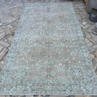 Beige 5' x 9' vintage turkish rug in wool and cotton, shown on the floor.