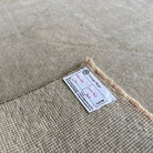 Close-up of the beige vintage turkish rug showing neutral details, hand-knotted weave, wool and cotton and low pile.