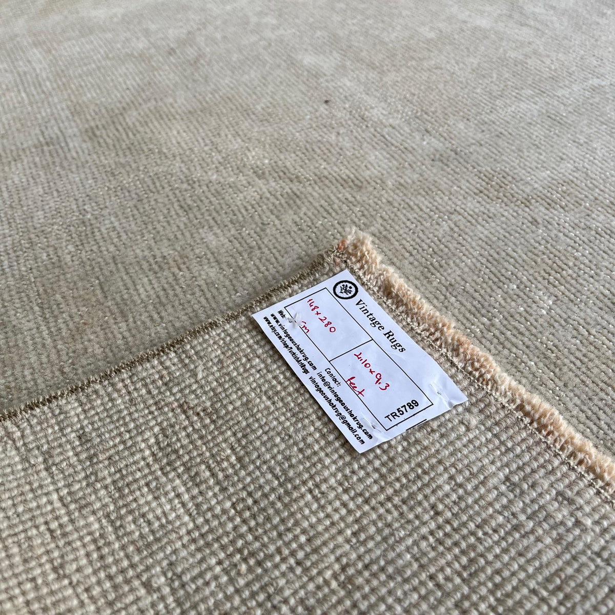 Close-up of the beige vintage turkish rug showing neutral details, hand-knotted weave, wool and cotton and low pile.