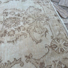 Close-up of the beige vintage turkish rug showing neutral details, hand-knotted weave, wool and cotton and low pile.