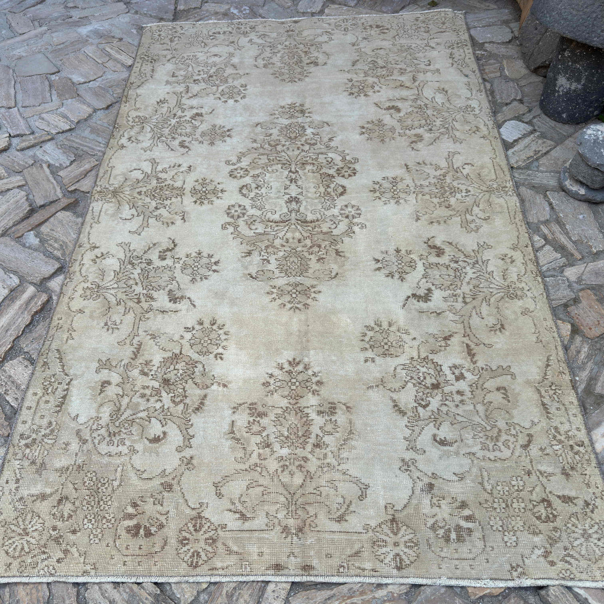 Beige 5' x 9' vintage turkish rug in wool and cotton, shown on the floor.