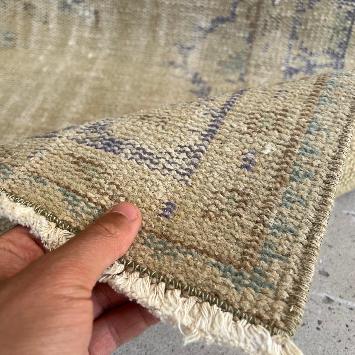 Close-up of the blue vintage turkish rug showing medallion details, hand-knotted weave, wool and cotton and low pile.
