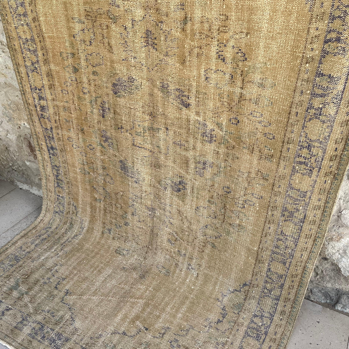 Blue 5' x 9' vintage turkish rug in wool and cotton, shown on the floor.