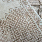 Close-up of the brown vintage turkish rug showing geometric details, hand-knotted weave, wool and cotton and low pile.