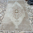 Brown 5' x 9' vintage turkish rug in wool and cotton, shown on the floor.