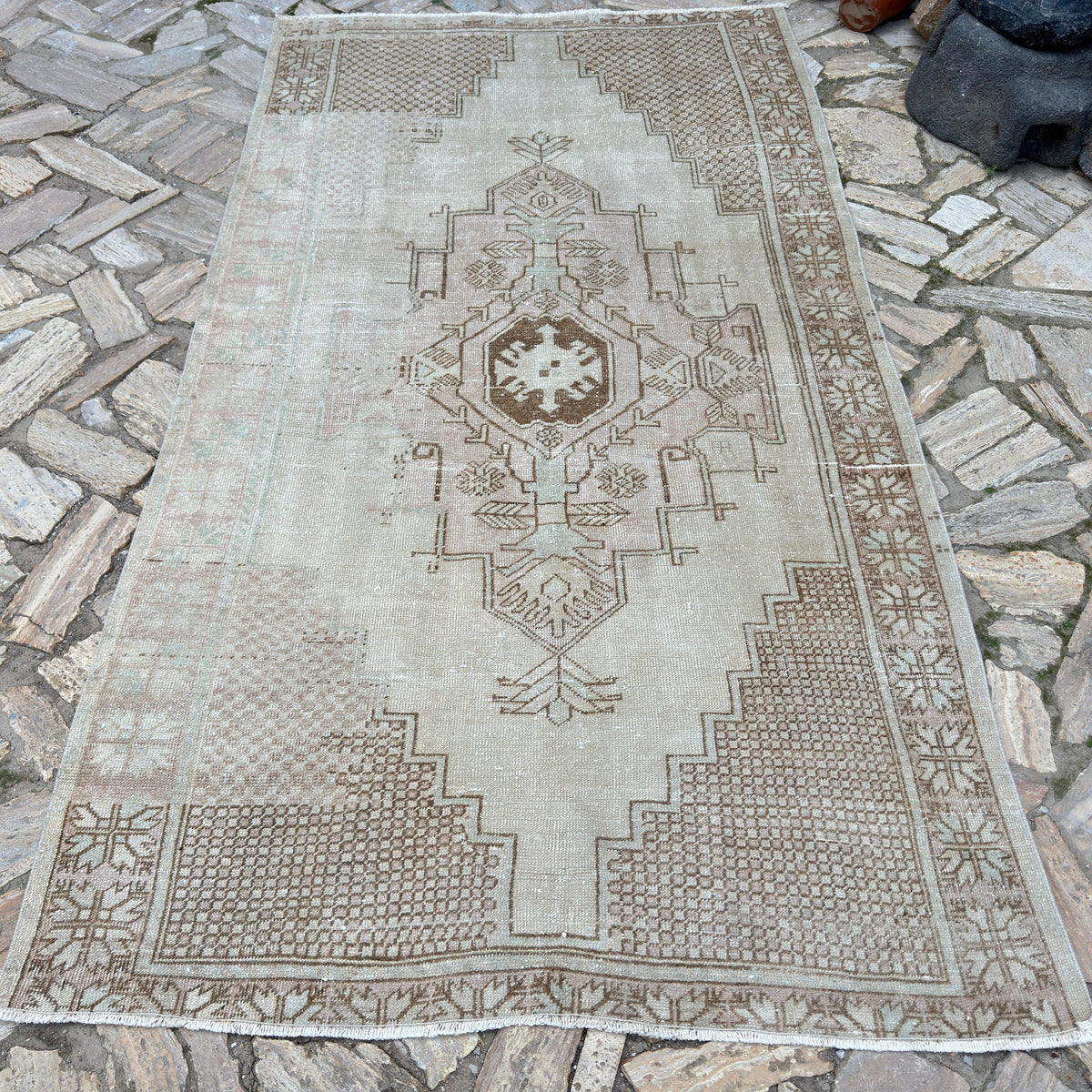 Brown 5' x 9' vintage turkish rug in wool and cotton, shown on the floor.