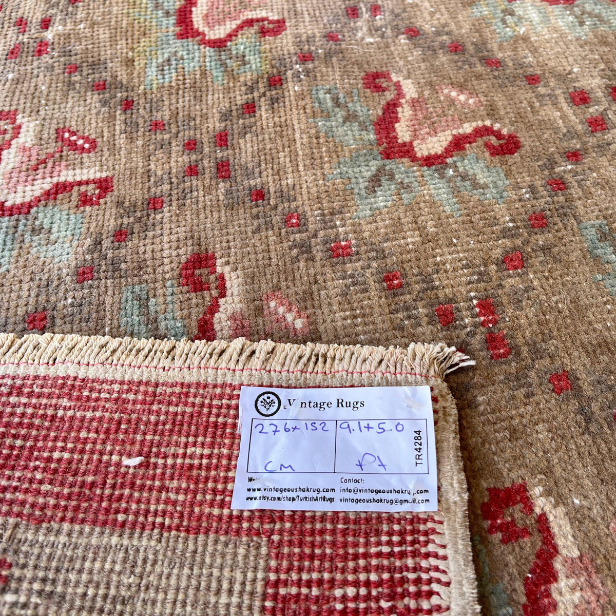 Close-up of the brown vintage turkish rug showing floral details, hand-knotted weave, wool and cotton and low pile.
