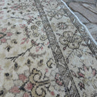 Close-up of the brown vintage turkish rug showing floral details, hand-knotted weave, wool and cotton and low pile.