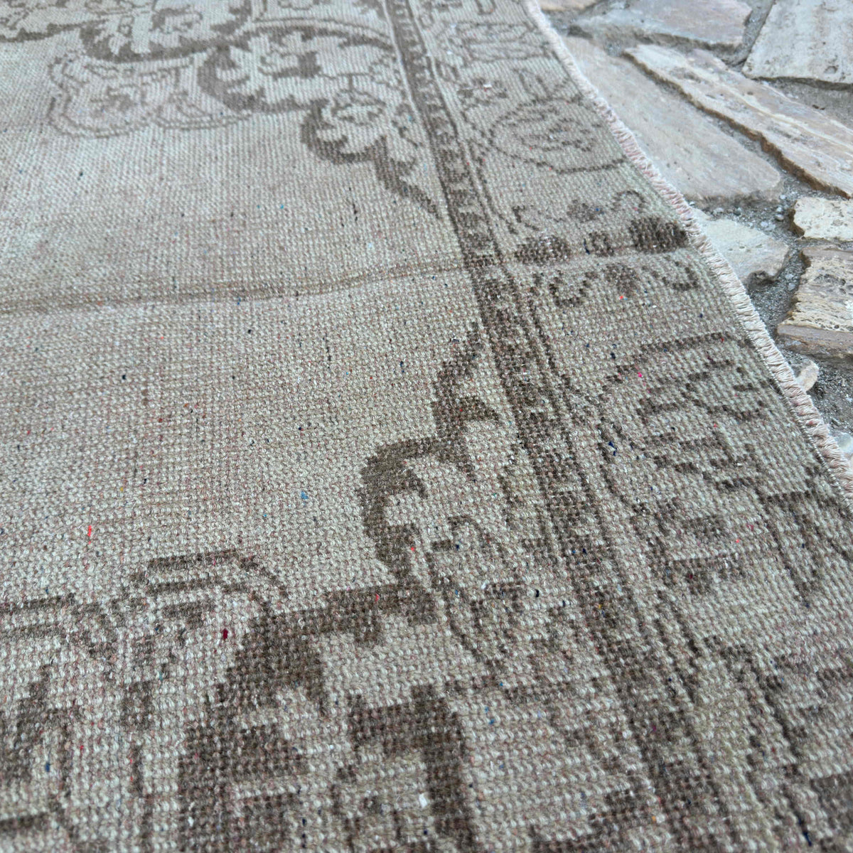 Close-up of the brown vintage turkish rug showing traditional details, hand-knotted weave, wool and cotton and low pile.