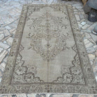 Brown 5' x 9' vintage turkish rug in wool and cotton, shown on the floor.