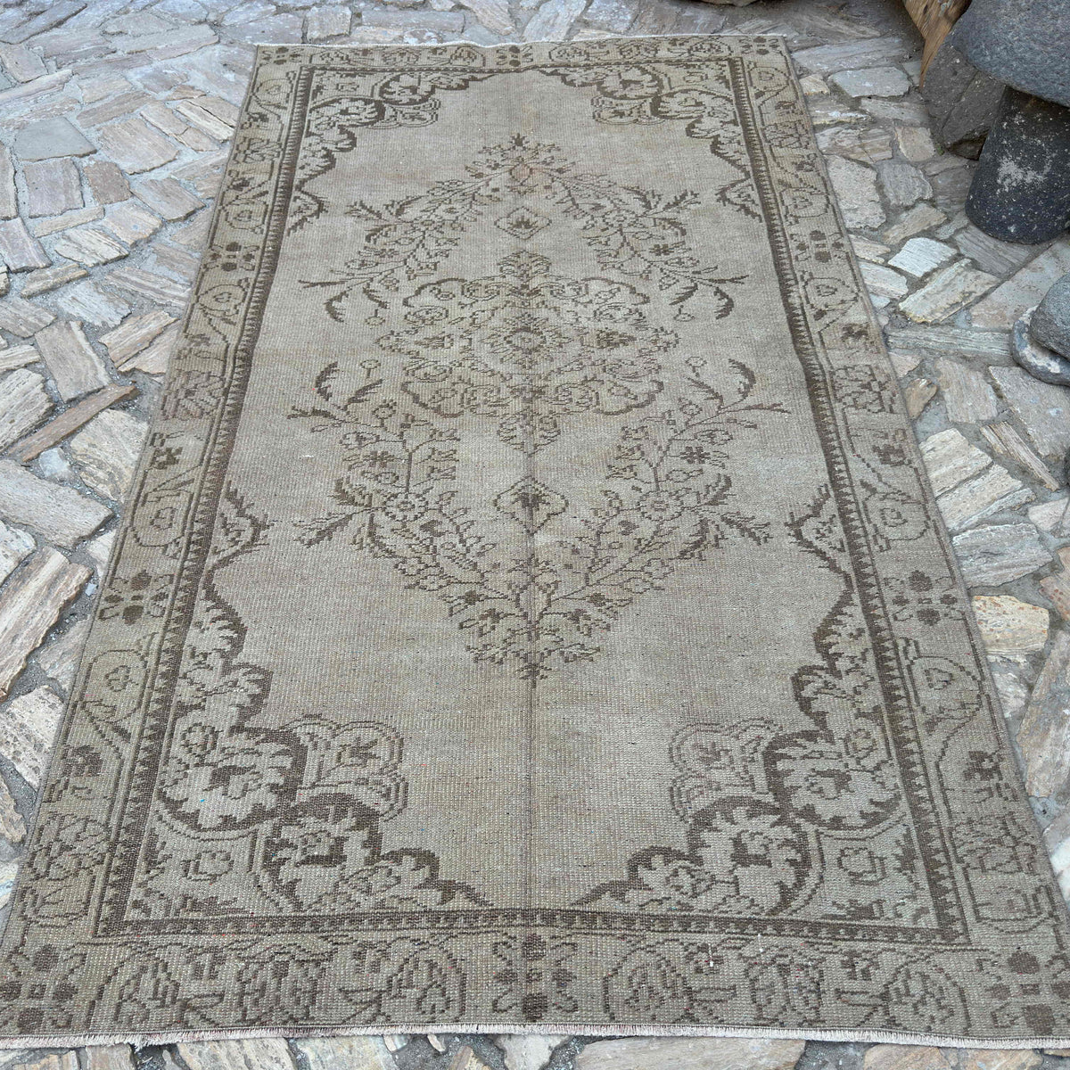 Brown 5' x 9' vintage turkish rug in wool and cotton, shown on the floor.