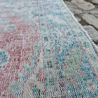 Close-up of the red vintage turkish rug showing medallion details, hand-knotted weave, wool and cotton and low pile.