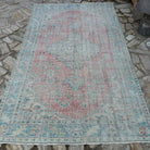 Red 5' x 9' vintage turkish rug in wool and cotton, shown on the floor.