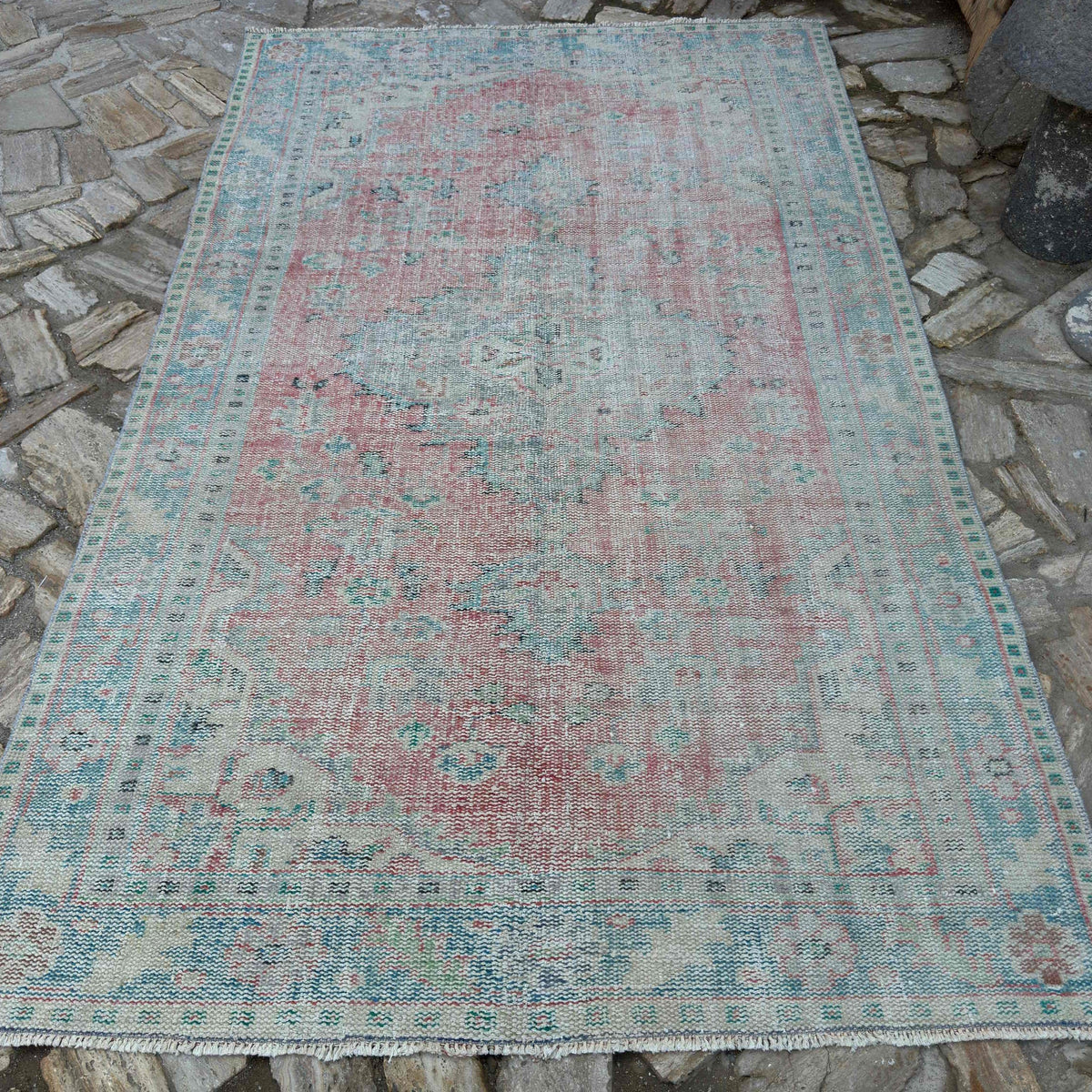 Red 5' x 9' vintage turkish rug in wool and cotton, shown on the floor.