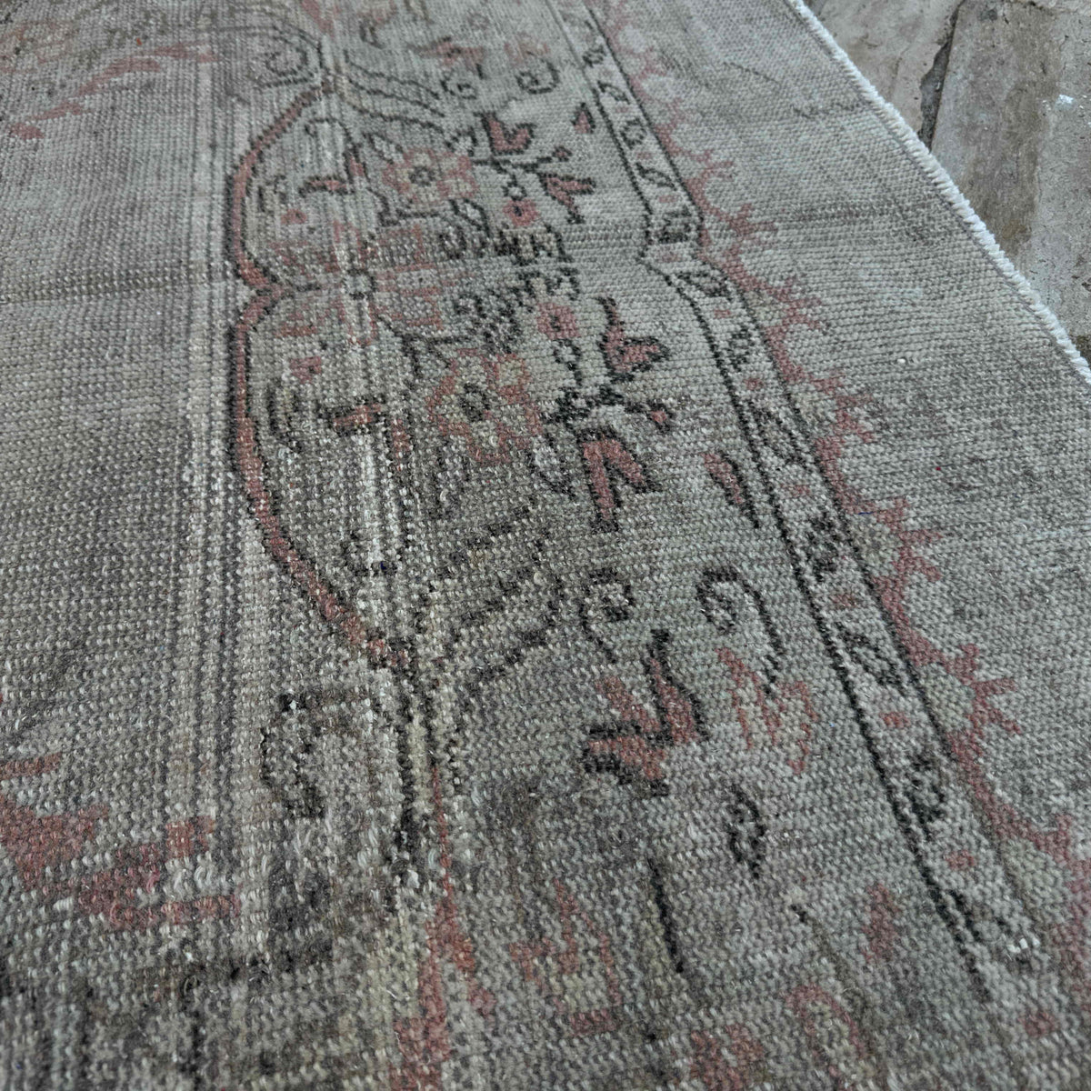 Close-up of the beige vintage turkish rug showing neutral details, hand-knotted weave, wool and cotton and low pile.
