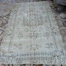 Beige 6' x 10' vintage turkish rug in wool and cotton, shown on the floor.