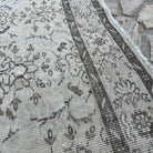 Close-up of the beige vintage turkish rug showing floral details, hand-knotted weave, wool and cotton and low pile.