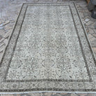 Beige 6' x 10' vintage turkish rug in wool and cotton, shown on the floor.