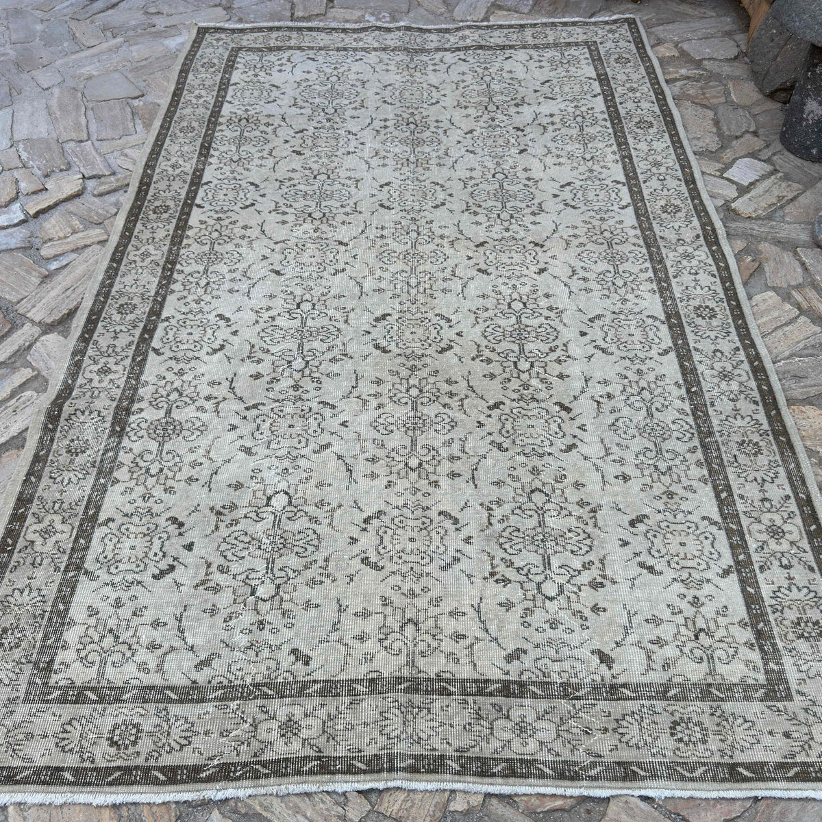Beige 6' x 10' vintage turkish rug in wool and cotton, shown on the floor.