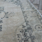 Close-up of the beige vintage turkish rug showing medallion details, hand-knotted weave, wool and cotton and low pile.