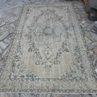 Beige 6' x 10' vintage turkish rug in wool and cotton, shown on the floor.
