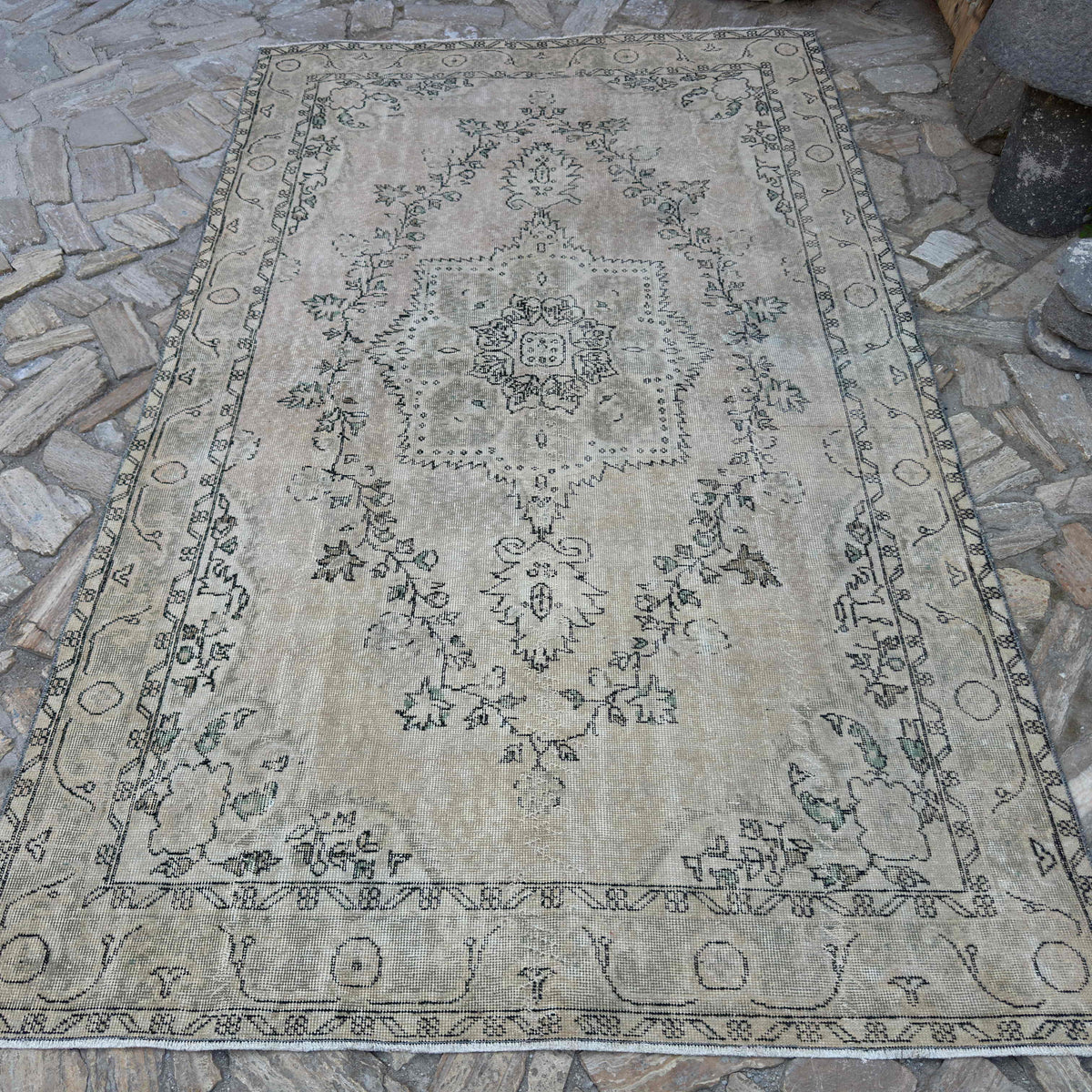 Beige 6' x 10' vintage turkish rug in wool and cotton, shown on the floor.