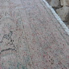 Close-up of the beige vintage turkish rug showing medallion details, hand-knotted weave, wool and cotton and low pile.