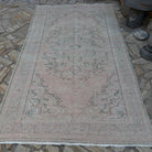 Beige 6' x 10' vintage turkish rug in wool and cotton, shown on the floor.