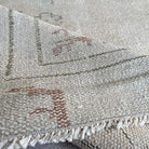 Close-up of the beige vintage turkish rug showing neutral details, hand-knotted weave, wool and cotton and low pile.