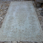 Beige 6' x 10' vintage turkish rug in wool and cotton, shown on the floor.