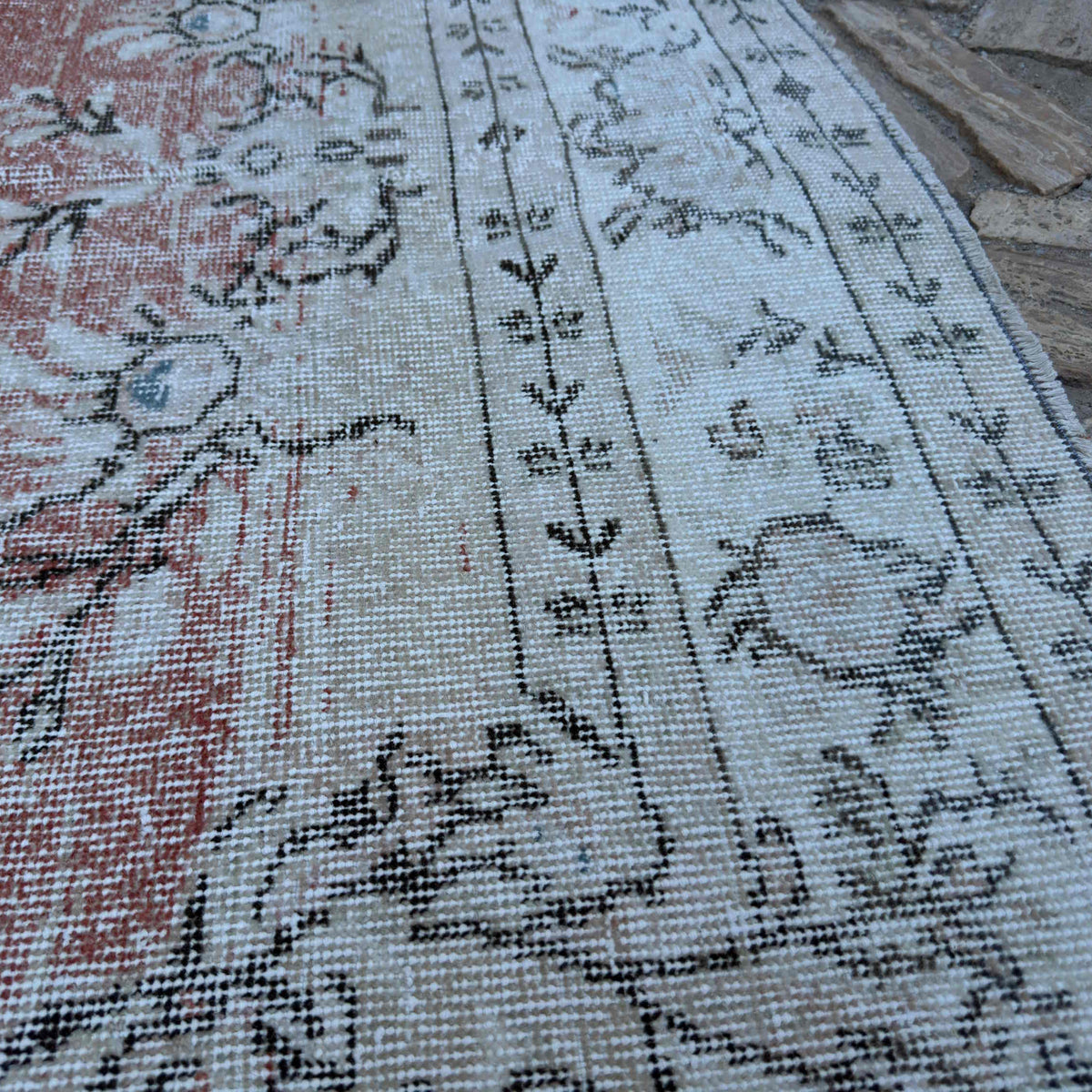 Close-up of the beige vintage turkish rug showing medallion details, hand-knotted weave, wool and cotton and low pile.