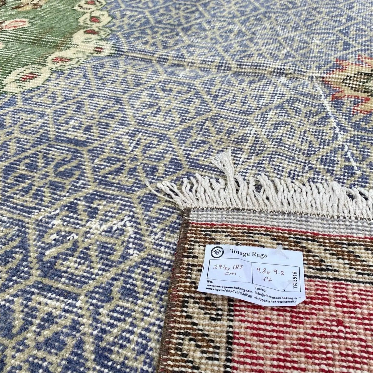Close-up of the blue vintage turkish rug showing medallion details, hand-knotted weave, wool and cotton and low pile.