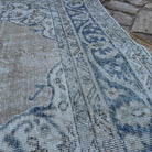 Close-up of the blue vintage turkish rug showing medallion details, hand-knotted weave, wool and cotton and low pile.