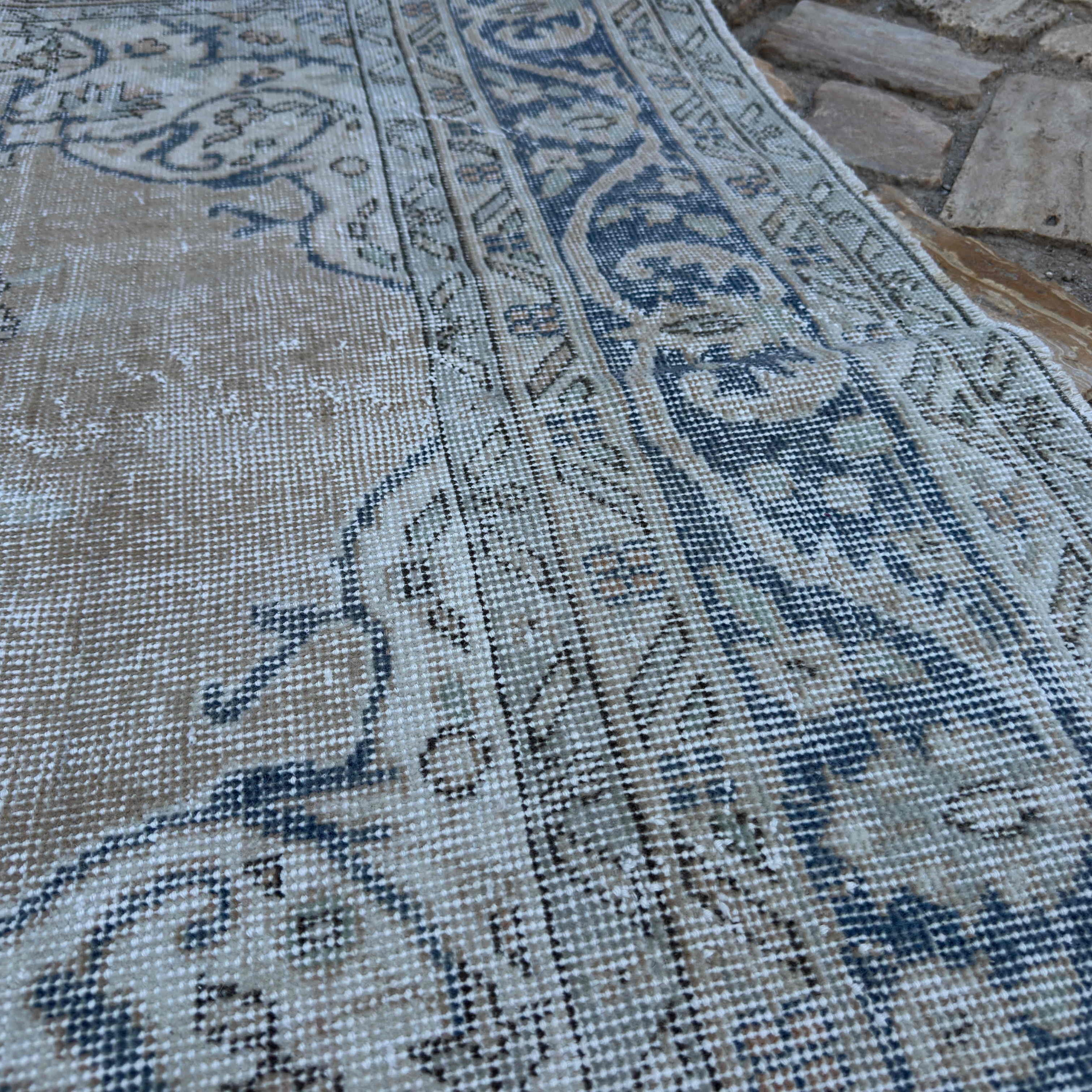 Close-up of the blue vintage turkish rug showing medallion details, hand-knotted weave, wool and cotton and low pile.