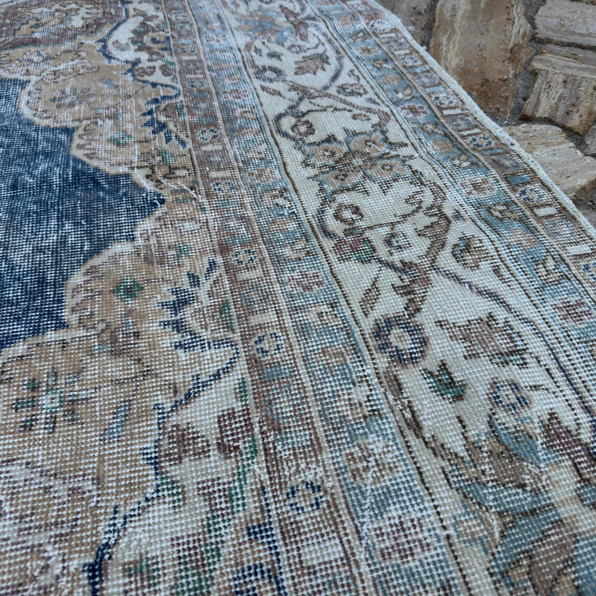 Close-up of the blue vintage turkish rug showing medallion details, hand-knotted weave, wool and cotton and low pile.