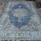 Blue 6' x 10' vintage turkish rug in wool and cotton, shown on the floor.