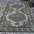 Brown 6' x 10' vintage turkish rug in wool and cotton, shown on the floor.